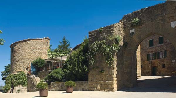 L'ingresso a Monticchiello, località che conserva ancora i tratti austeri delle fortezze medievali, contrasta con il carattere rinascimentale di Pienza.