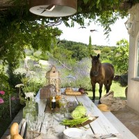 Il patio esterno ospita un'accogliente e raffinata zona pranzo dall'allure country chic