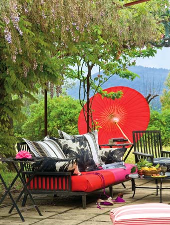 Una delle zone conversazione esterne, con arredi colorati, come l'ombrellone e le sedute in legno