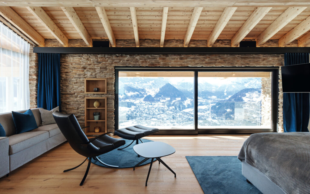 Una delle camere da letto dello chalet sulle Alpi si affaccia sul panorama montano.
