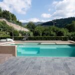 PIscina con parete trasparente circondata dal verde