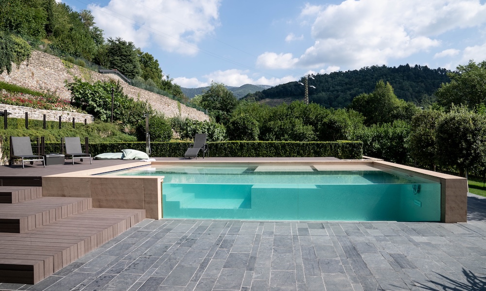 PIscina con parete trasparente circondata dal verde
