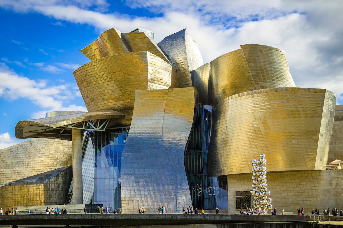 La struttura del Guggenheim Museum, articolata in volumi curvilinei rivestiti in titanio, vetro e pietra calcarea, crea un dialogo costante con il fiume Nervión e con la luce della città.