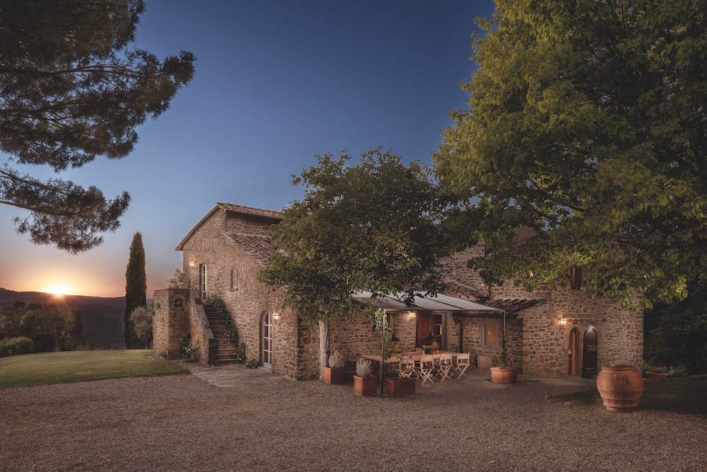 Vista notturna di una casa colonica toscana (nel Chianti) che, grazie all'attento restauro, esprime un nuovo modo di abitare: più luce, più dialogo tra gli ambienti, maggiore permeabilità visiva e una nuova qualità dello spazio.