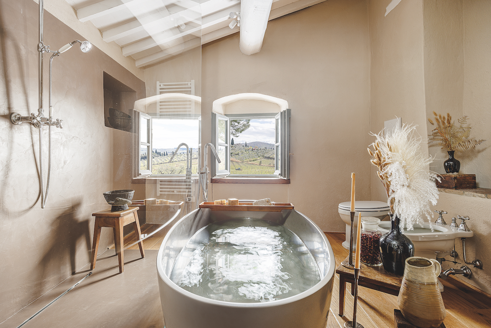 Una bella immagine del bagno dove la vasca è protagonista al centro e la finestra rende possibile la relazione costante con il paesaggio.