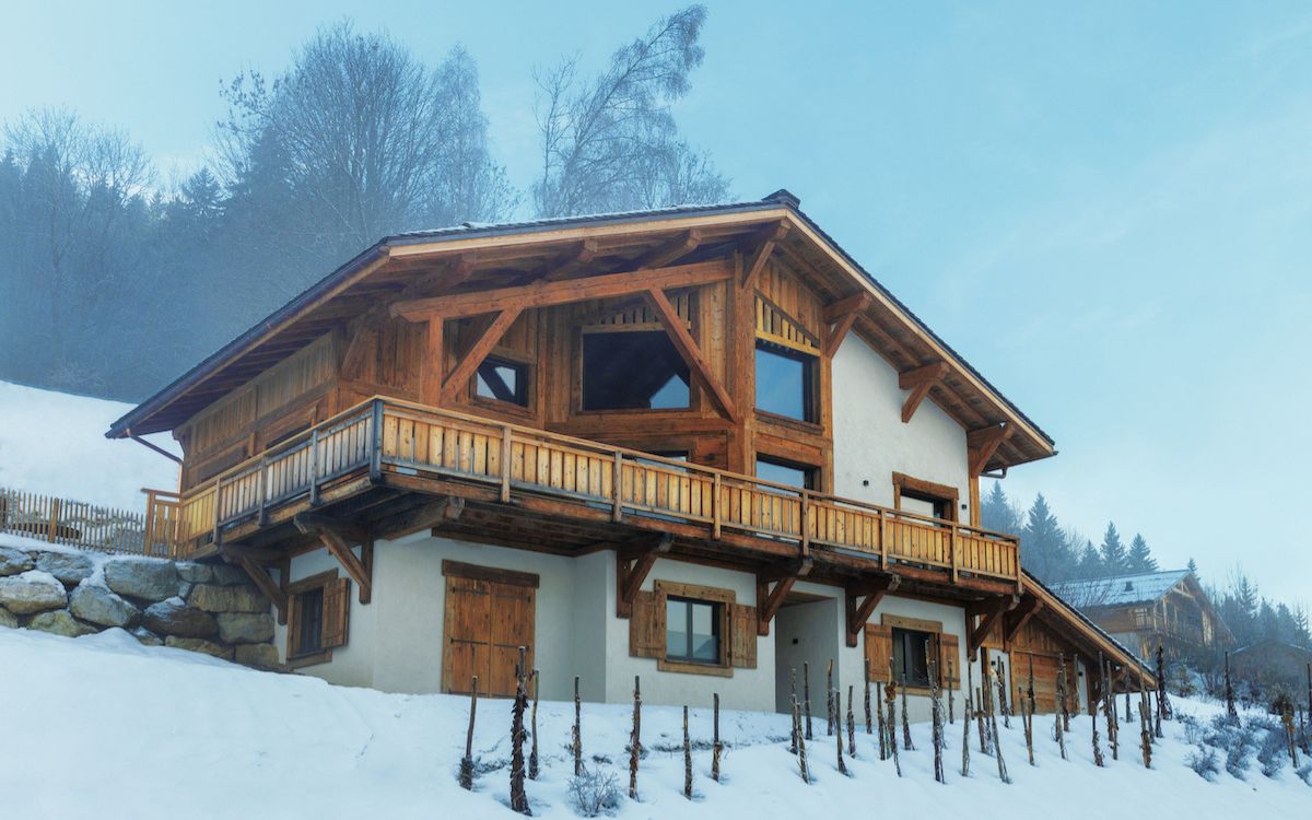 Vista esterna di uno chalet in legno nel paesaggio alpino della Savoia.