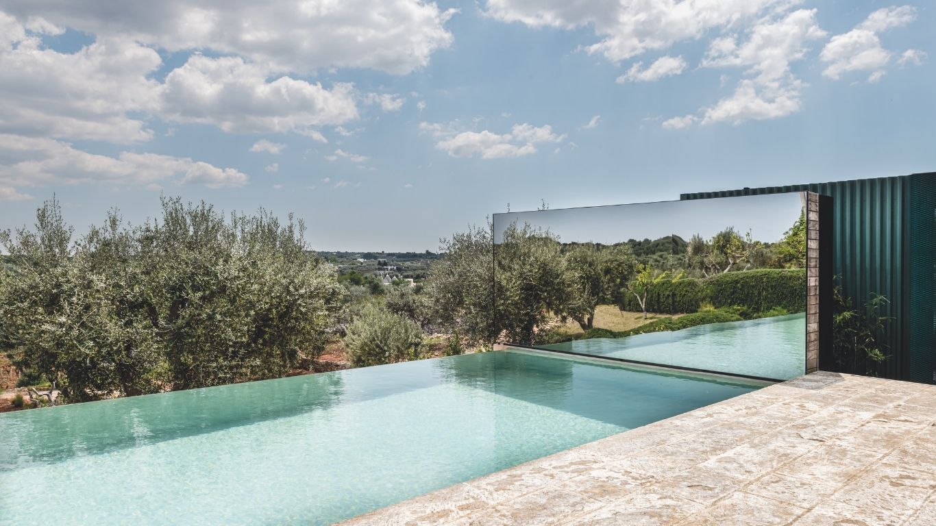 Pezzo forte del trullo con piscina in Puglia è la piscina a sfioro, realizzata su disegno da Studio Talent che
si allunga nel paesaggio grazie alla parete a specchio che ne moltiplica la percezione.